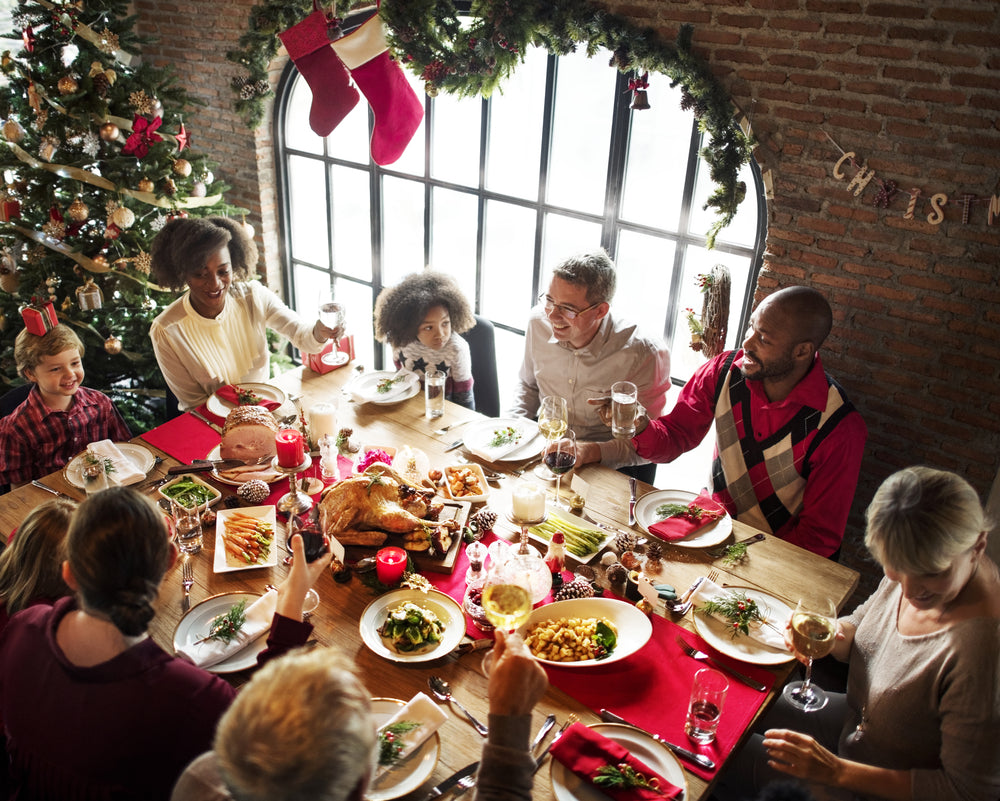 People gathered around a table celebrating Christmas. eventclothing.com